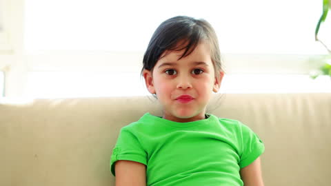 Child Happily Enjoying Apple on Sofa