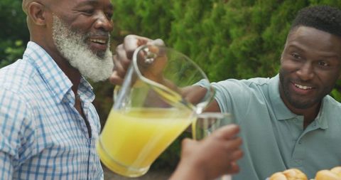 Family Bonding Outdoor Breakfast with Juice Pouring