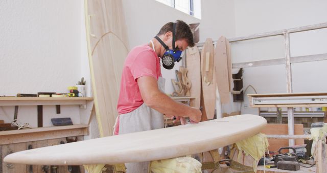 Craftsman Shaping Surfboard Wearing Protective Mask in Wood Workshop - Download Free Stock Images Pikwizard.com