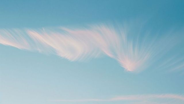 Pastel Pink Cirrus Cloud in Clear Blue Sky