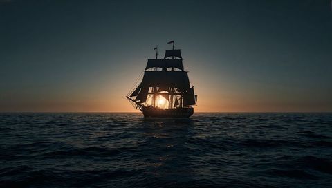 Sunset Silhouette of Majestic Sailing Ship over Waves