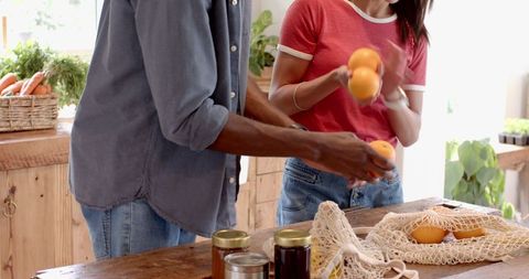 Couple organizing fresh produce in bright sustainable kitchen