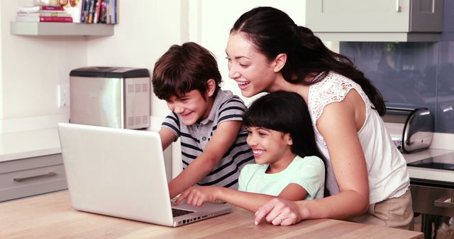 Mother and Two Children Smiling While Using Laptop in Kitchen - Download Free Stock Images Pikwizard.com