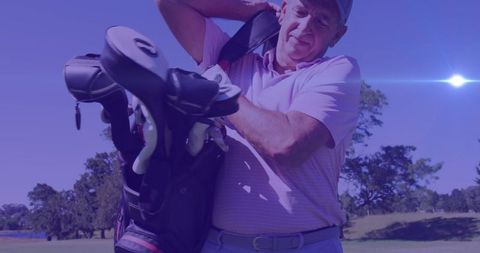 Senior golfer enjoying a sunny day on golf course with equipment