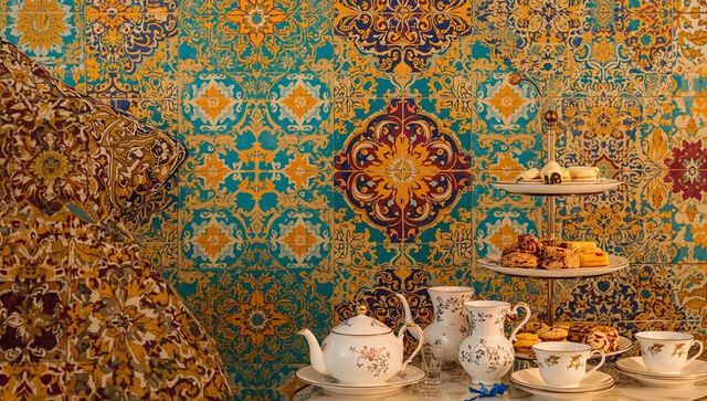 Turquoise gold mosaic tea nook with porcelain teapot, cups and tiered pastries