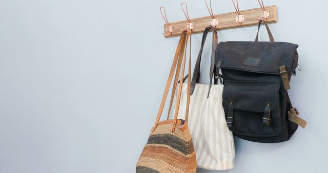 Hanging Bags on Wooden Wall Rack against Light Blue Background - Download Free Stock Images Pikwizard.com