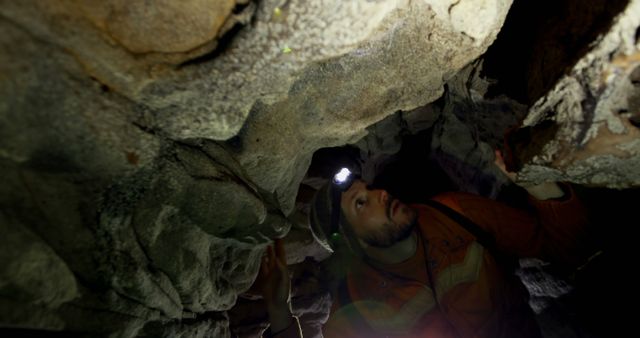 Caucasian man wearing headlamp looking up, exploring dark natural cave system, copy space - Download Free Stock Photos Pikwizard.com