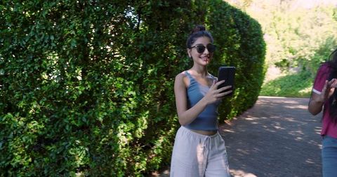 Friends Enjoying Technology on a Park Walk