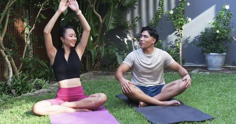 Couple Practicing Outdoor Yoga on Backyard Lawn Stretching and Smiling in Sunlight