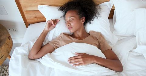 African American Woman Sleeping Peacefully in Minimalist Bedroom