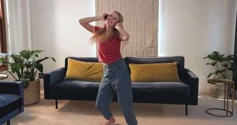 Teen Girl Dancing Freely at Home Listening to Music with Headphones
