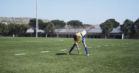 Athletic youth practicing soccer drills on field