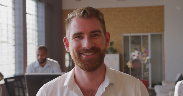 Smiling Man with Beard in Modern Office Environment - Download Free Stock Images Pikwizard.com