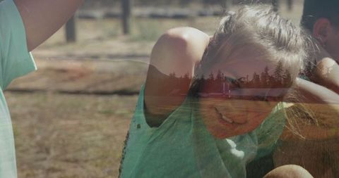 Siblings Playing Outdoors in Sunlit Pasture