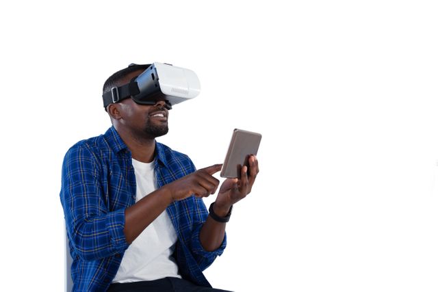 Man using virtual reality headset and digital tablet against white background