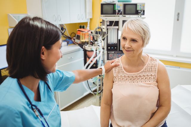 Female doctor consoling senior patient in hospital room. Ideal for use in healthcare, medical, and patient care contexts. Can be used in articles, brochures, and websites focusing on medical support, patient care, and doctor-patient relationships.