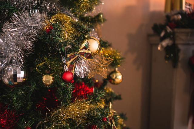 Close-up view of a beautifully decorated Christmas tree with various ornaments, tinsel, and baubles. Ideal for holiday-themed projects, greeting cards, festive advertisements, and seasonal blog posts.