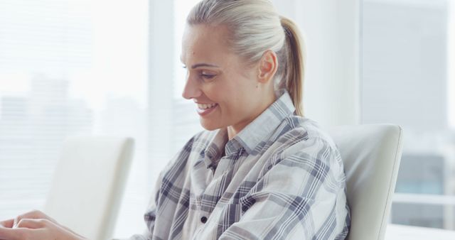 Smiling Professional Woman Working on Laptop in Bright Office - Download Free Stock Images Pikwizard.com