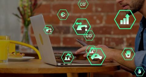 Remote professional multitasking on laptop and smartphone with green sustainability icons