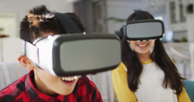 Kids fully immersed in virtual reality experience, smiling and having fun with VR headsets. Perfect for use in advertising technology, gaming in educational environments, or promoting the benefits of virtual reality for children.