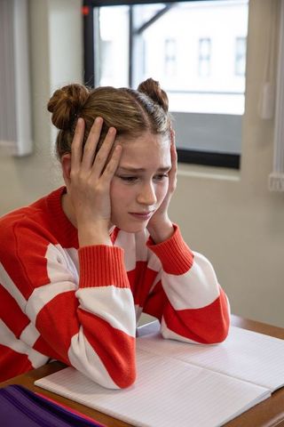 Frustrated schoolgirl focusing on homework