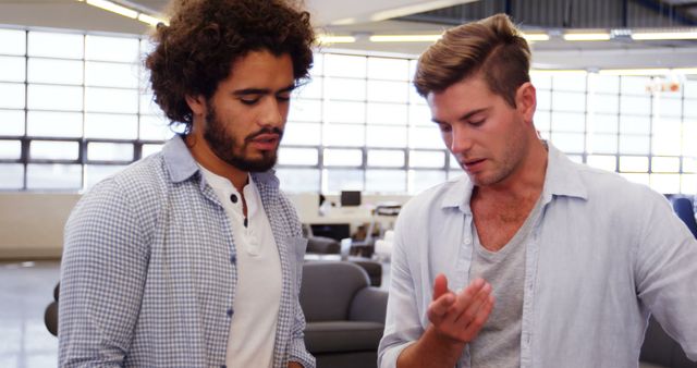 Two men of different ethnicities engage in a serious workplace discussion. - Download Free Stock Photos Pikwizard.com