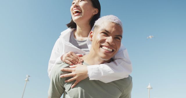 Happy Multiethnic Couple Laughing Piggyback at Beach on Sunny Day - Download Free Stock Images Pikwizard.com