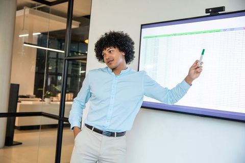 Professional presenting data on office screen with confidence