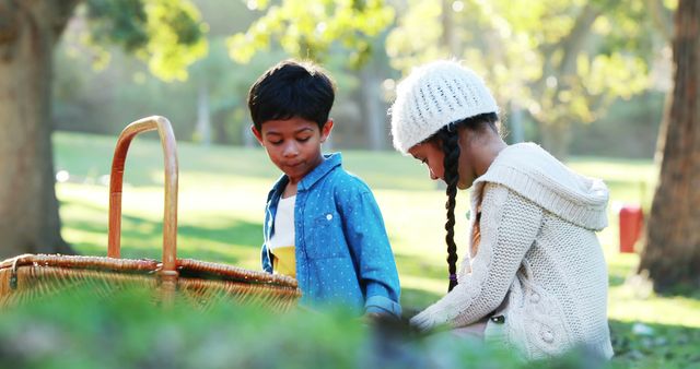 Boy and girl sitting on grass with picnic basket in park 4k