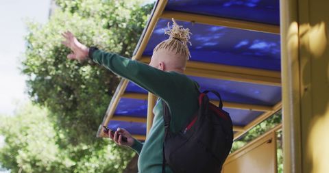 Urban african american man with dreadlocks using smartphone