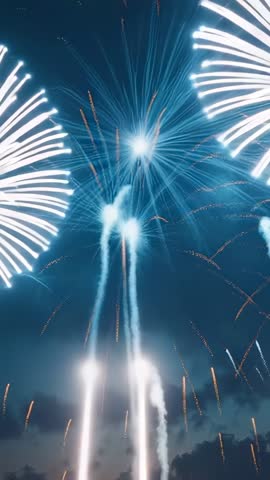 Vertical video capturing launching fireworks bursting into blue blooms above dusk treeline