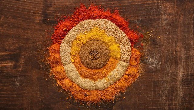 Showcasing concentric spice rings on rustic wooden tabletop, colorful overhead flat-lay
