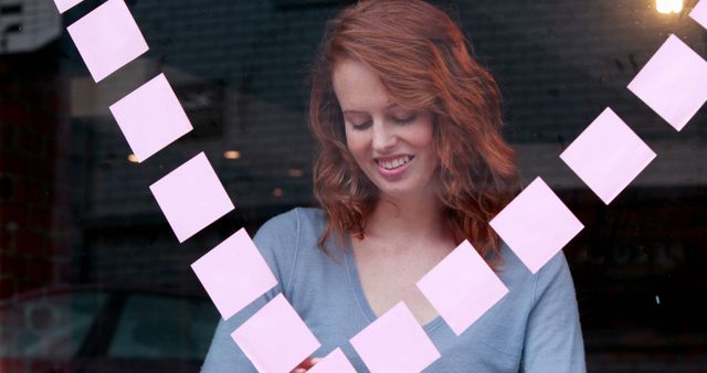 Young Woman Arranging Pink Sticky Notes in Heart Shape on Window - Download Free Stock Images Pikwizard.com