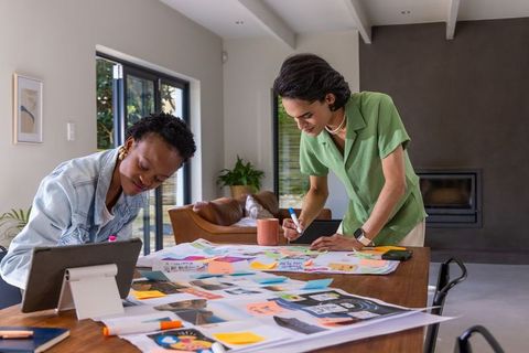 African american woman and asian man collaborating on creative mockups at home workspace