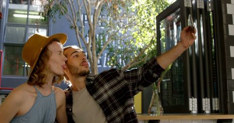 Joyful Caucasian Couple taking Selfie Outdoors on Sunny Day