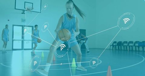 Youth basketball player dribbling through cones in school gym with digital network overlay