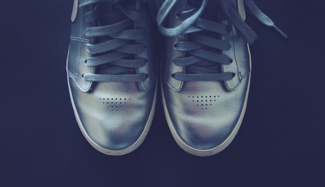 Stylish Metallic Sneakers with Dark Laces Against Dark Background - Download Free Stock Photos Pikwizard.com