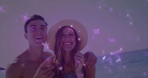 Couple enjoying beach vacation under sparkling filter effect