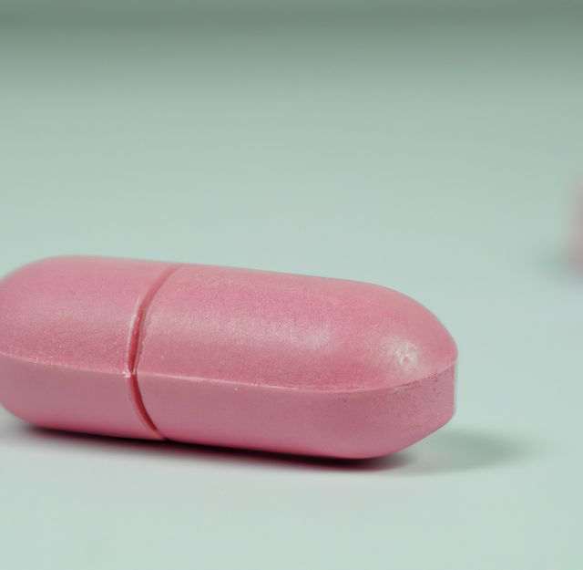 This shows a close-up view of a pink capsule on a light background, ideal for representing medication, pharmaceutical industry, or healthcare themes. Suitable for use in articles, advertisements, and educational materials related to healthcare, illness prevention, and treatment.