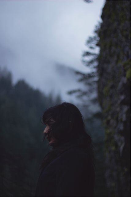 The image features a woman standing in a forest, surrounded by fog and trees, creating a mysterious and moody atmosphere. This could be used for themes relating to nature, mystery, solitude, or contemplative moments. Ideal for blogs, websites, or marketing materials focused on outdoor adventures, atmospheric settings, or psychological themes.