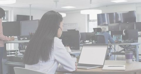 Businesswoman Working with Laptop and Headset in Modern Office