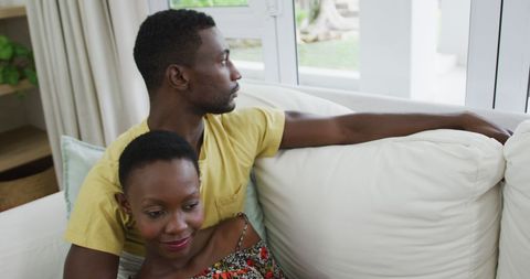 Relaxed Couple Embracing on Couch by Window