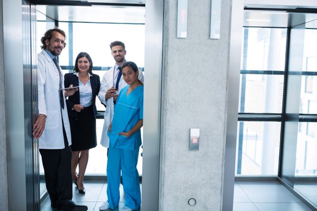 Doctors and businesswoman standing in elevator in hospital