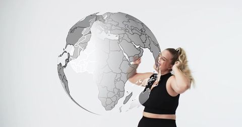 Woman reaching and touching semi-transparent globe for global fitness branding and wellness