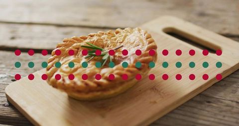 Rustic savory hand pies with braided crust on wooden cutting board and rosemary garnish