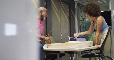 Designers Collaborating on Wind Turbine Project in Office Meeting