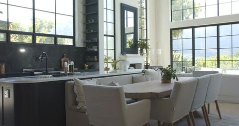 Sunlit Open-Plan Kitchen Dining Showcasing Solid Wood Table and Padded Chairs