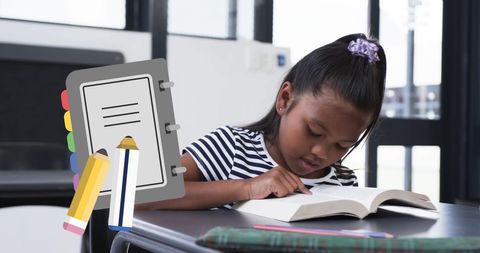 Focused Young Student Reading Book at Desk