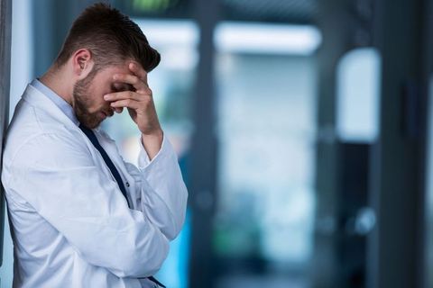 Stressed Doctor Leaning Against Wall Contemplating Tough Decisions