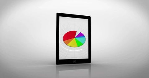 Tablet displaying colorful pie chart on glossy surface for digital analytics and data visualization